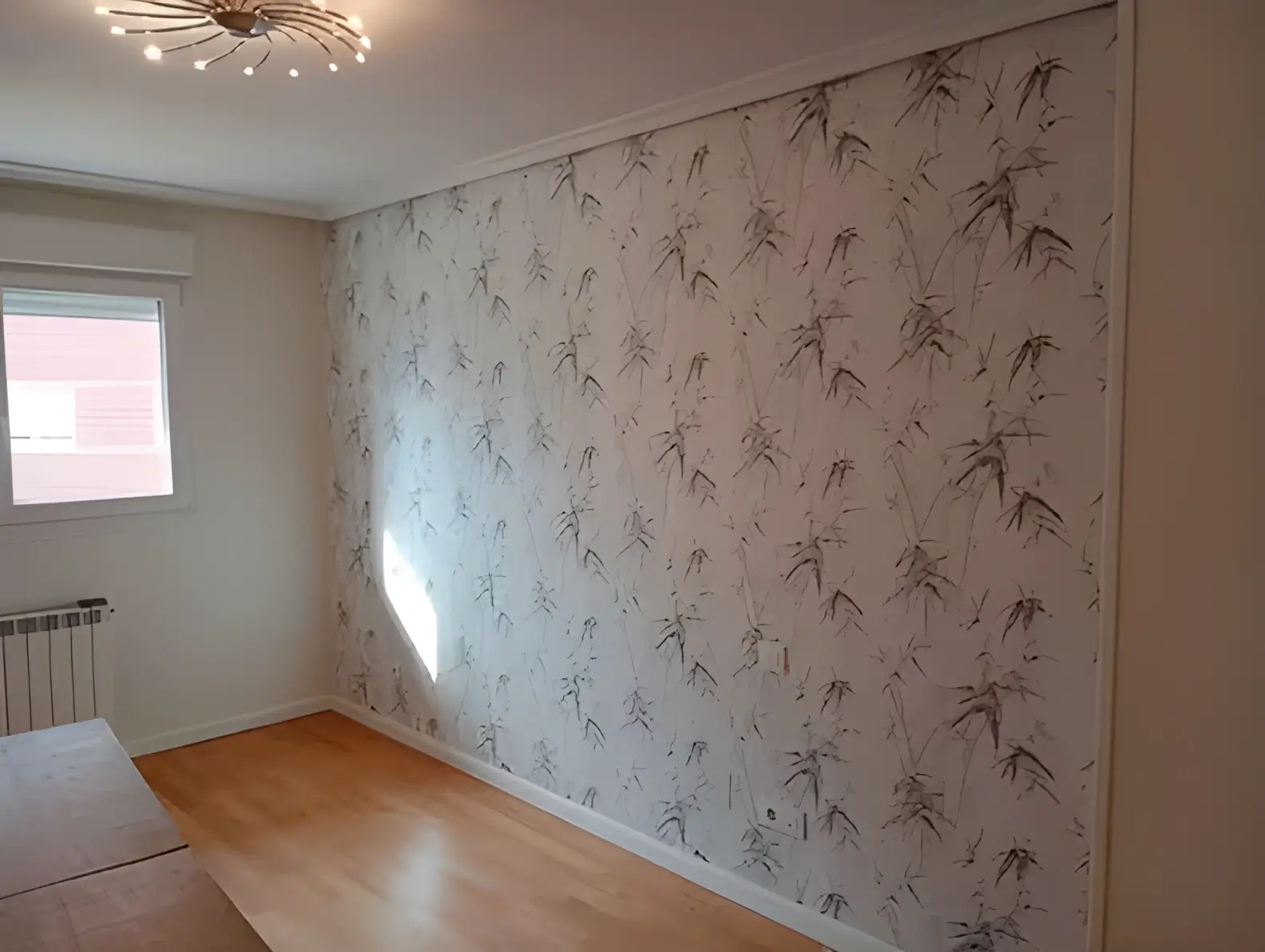 Los Pintores Huelva colocando papel pintado en pared de acento de habitación luminosa