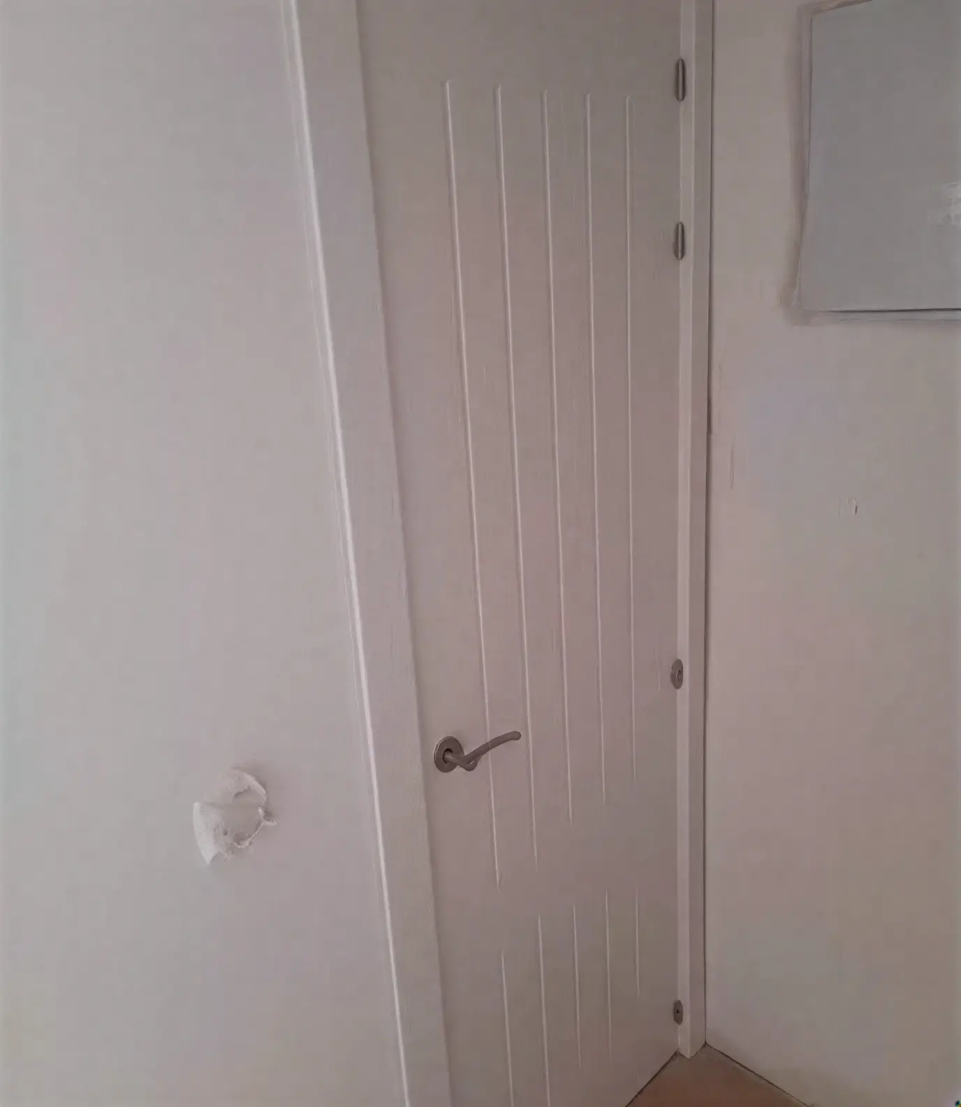 Puerta moderna con ranuras lacada en blanco por pintores profesionales en Huelva